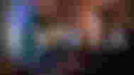 Evnia logo in white in front of a blurry image of someone gaming at a PC setup.